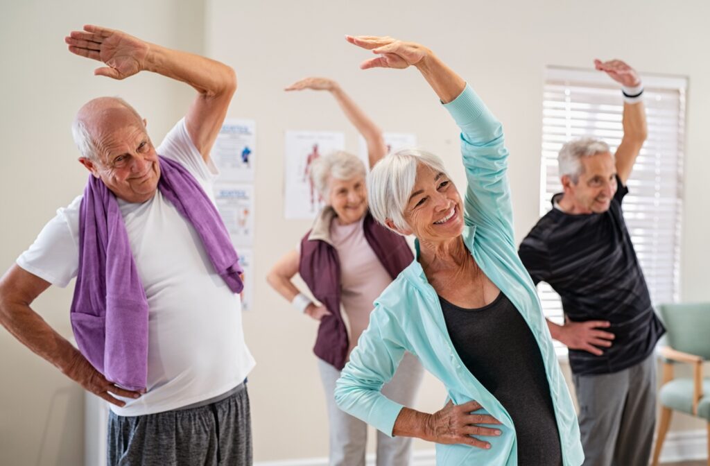 a group of seniors are stretching together as part of their senior exercise program.