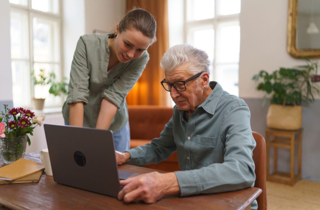 An adult helps their senior parent research assisted living communities online to find the best match for their needs